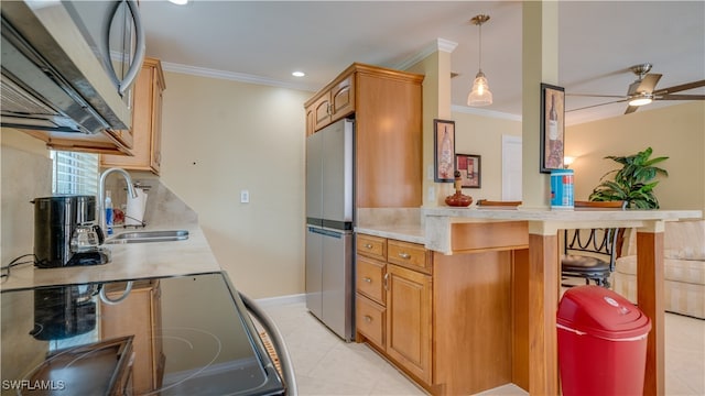 kitchen featuring pendant lighting, stainless steel appliances, sink, ornamental molding, and a breakfast bar