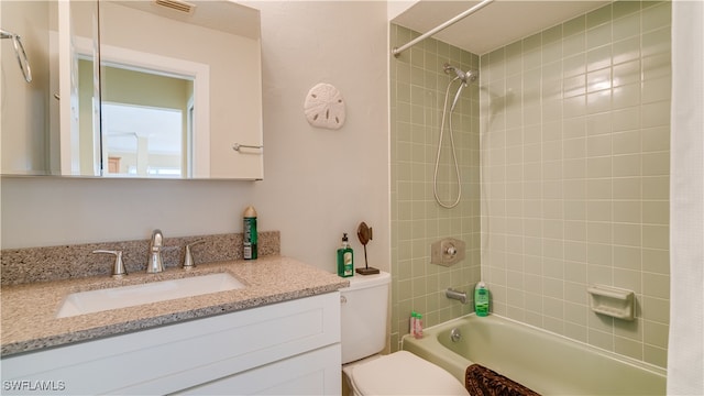 full bathroom with vanity, toilet, and tiled shower / bath