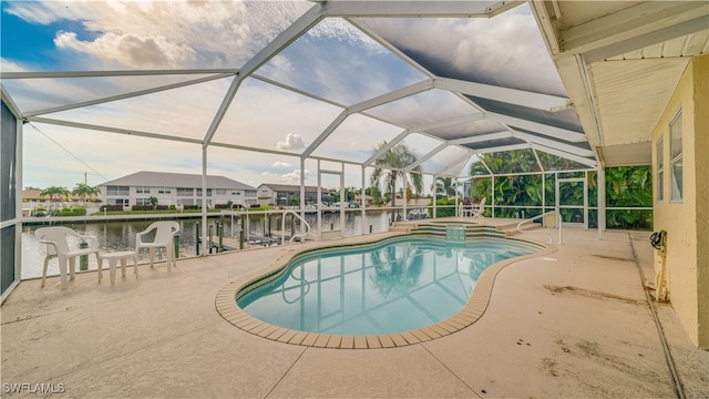 view of swimming pool with a patio area, a lanai, a jacuzzi, and a water view