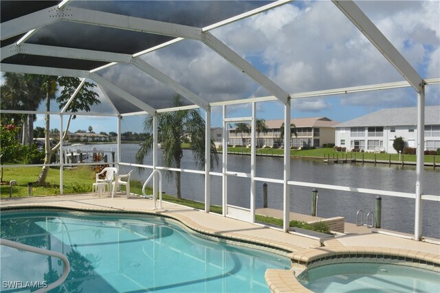 view of swimming pool featuring glass enclosure, an in ground hot tub, a water view, and a patio