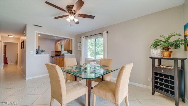 tiled dining area featuring ceiling fan and sink