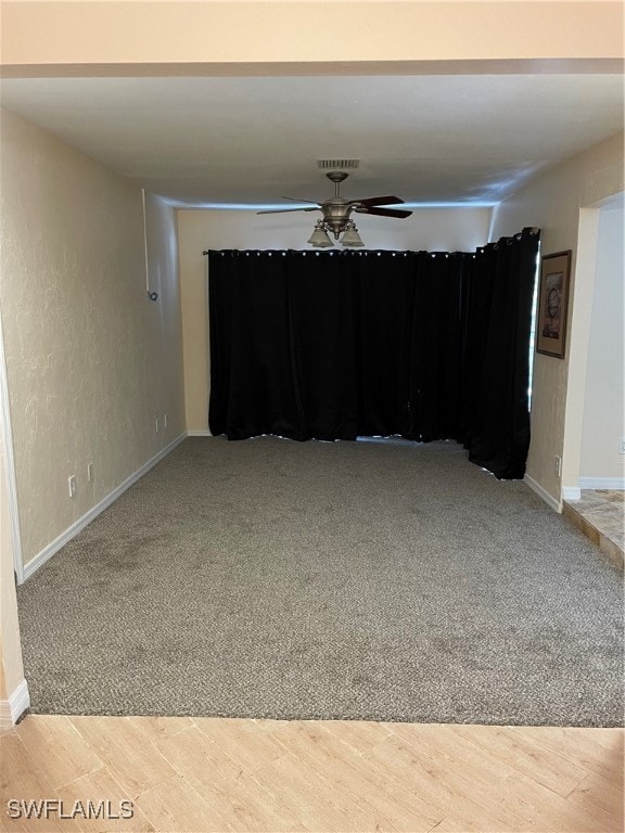 carpeted spare room featuring ceiling fan