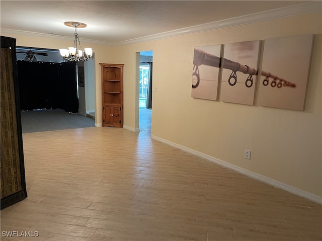 spare room featuring crown molding, wood-type flooring, and a notable chandelier