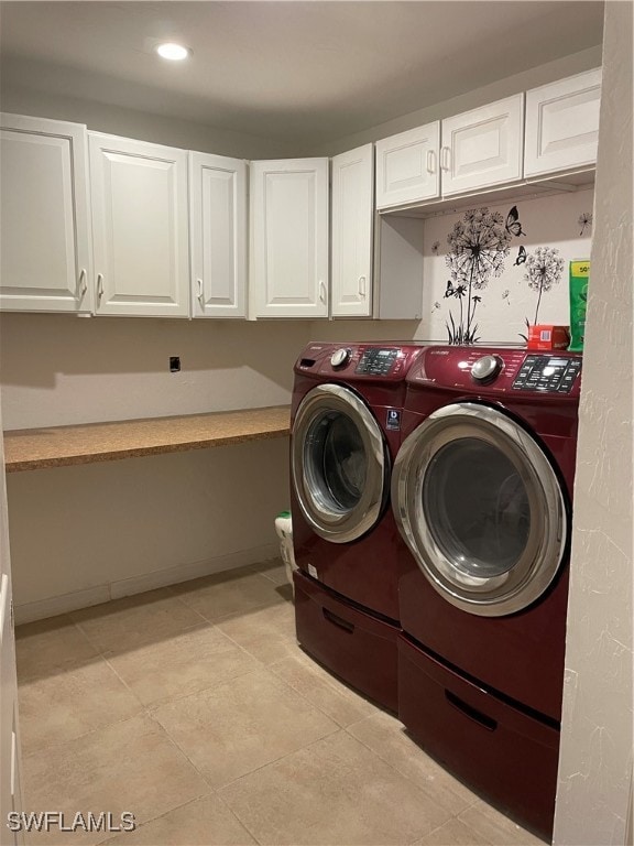 laundry room featuring cabinets, separate washer and dryer, and light tile patterned flooring