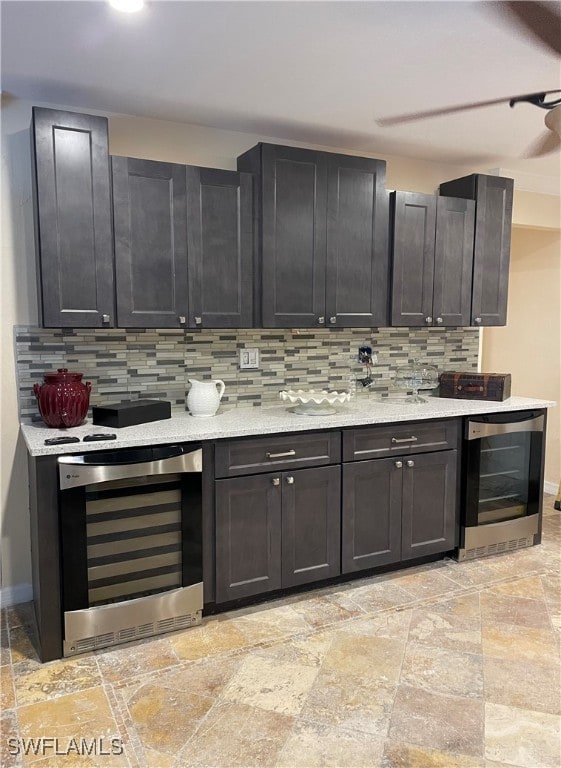 kitchen with beverage cooler, light stone countertops, and tasteful backsplash