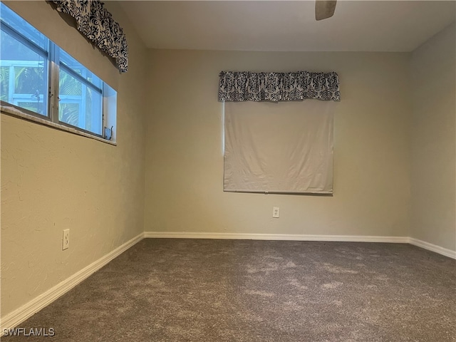 carpeted spare room featuring ceiling fan