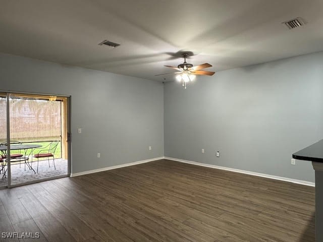 unfurnished room featuring dark wood-type flooring and ceiling fan