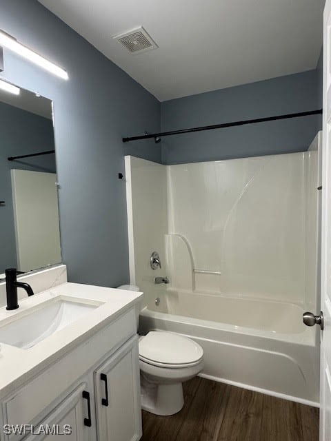 full bathroom with vanity, shower / washtub combination, hardwood / wood-style floors, and toilet