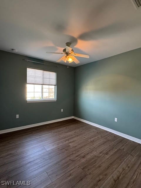 empty room with dark hardwood / wood-style floors and ceiling fan