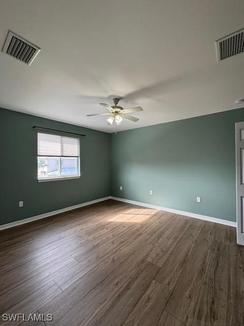 empty room with ceiling fan and dark hardwood / wood-style flooring