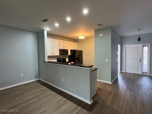 kitchen featuring black appliances, white cabinets, kitchen peninsula, and dark hardwood / wood-style flooring