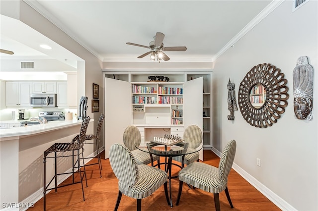 dining room with ceiling fan, wood-type flooring, and ornamental molding