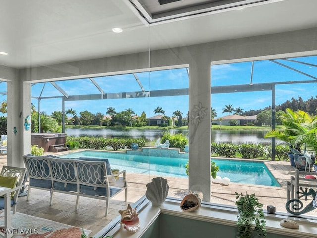 view of pool with a patio area, a lanai, a water view, and a hot tub