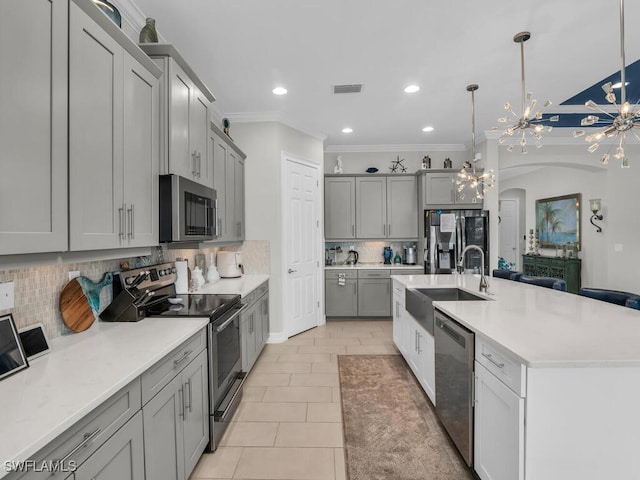 14748 Windward Ln, Naples, FL 34114 - kitchen featuring a chandelier, gray cabinetry, appliances with stainless steel finishes, arched walkways, and a sink