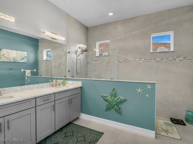 bathroom featuring vanity, a tile shower, and tile patterned flooring