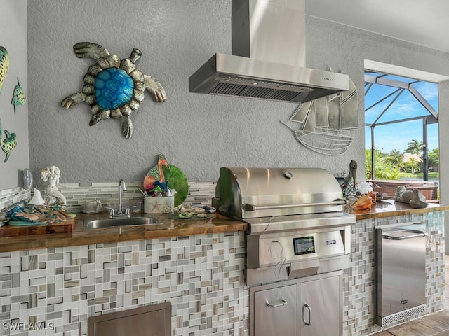 kitchen with sink, exhaust hood, and wood counters