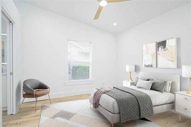 bedroom with lofted ceiling, ceiling fan, and light wood-type flooring