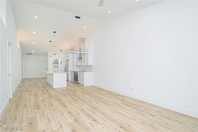 unfurnished living room with high vaulted ceiling and light hardwood / wood-style flooring