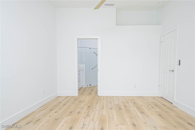 unfurnished bedroom with a spacious closet and light wood-type flooring