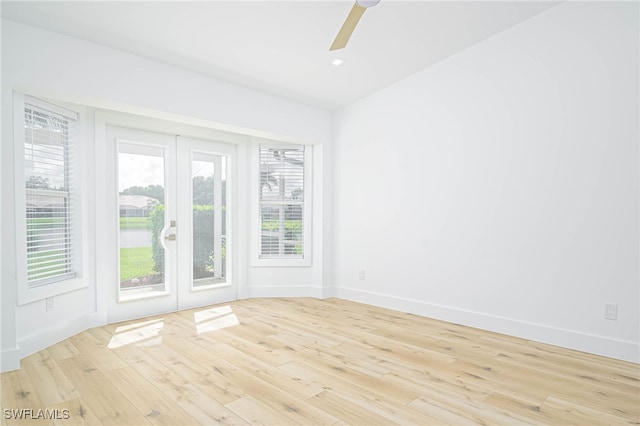 empty room with ceiling fan and light hardwood / wood-style flooring