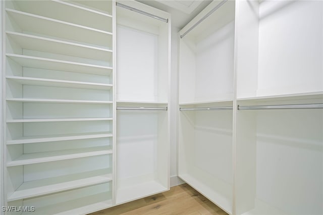 spacious closet with light hardwood / wood-style flooring