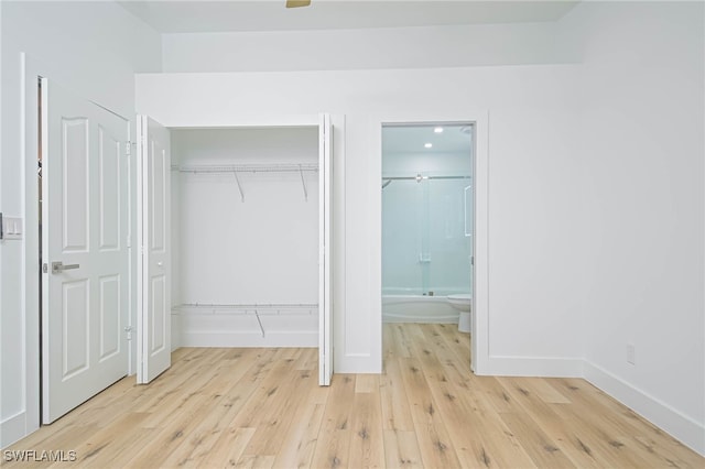 unfurnished bedroom with light wood-type flooring and connected bathroom