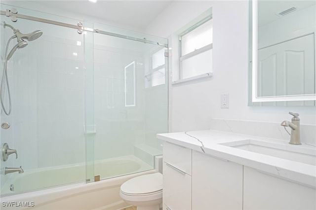 full bathroom featuring vanity, toilet, and combined bath / shower with glass door