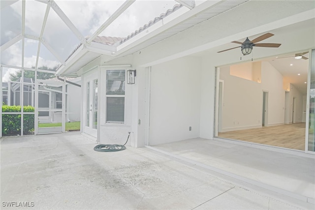 unfurnished sunroom featuring a healthy amount of sunlight, ceiling fan, and vaulted ceiling