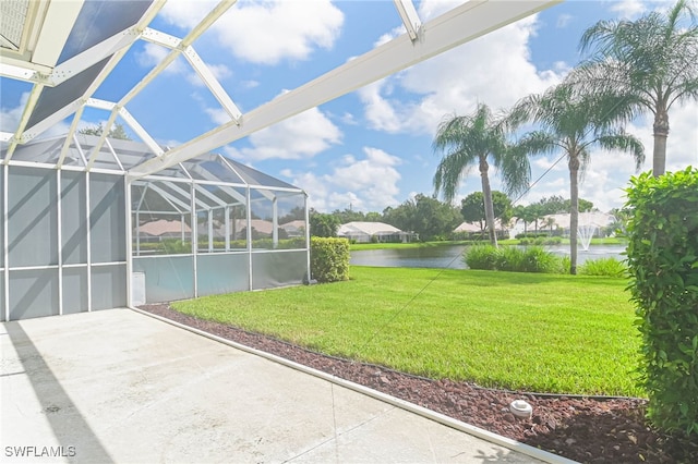 view of yard featuring a water view and glass enclosure