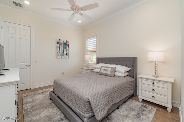 bedroom featuring ceiling fan, hardwood / wood-style floors, and crown molding