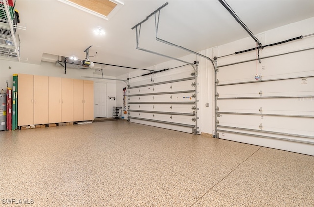 garage featuring electric water heater and a garage door opener