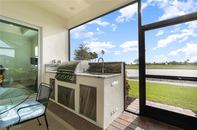 sunroom / solarium with sink, a water view, and a healthy amount of sunlight