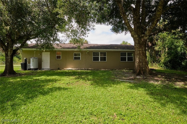 rear view of house featuring a yard