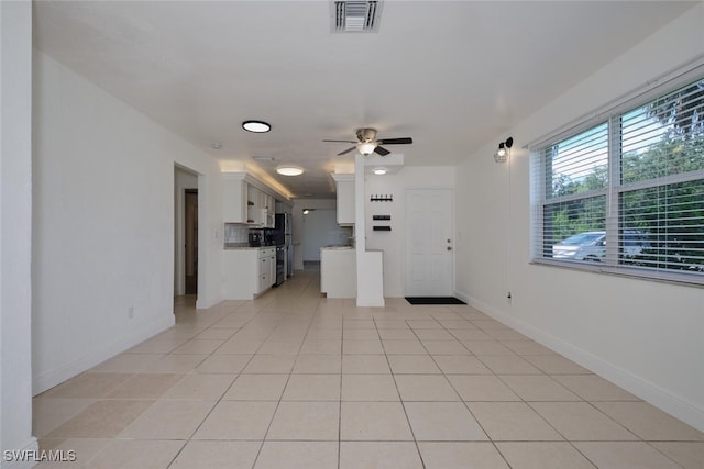 unfurnished living room featuring ceiling fan and light tile patterned floors