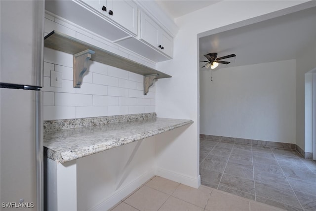 kitchen featuring fridge, white cabinetry, ceiling fan, and light tile patterned floors