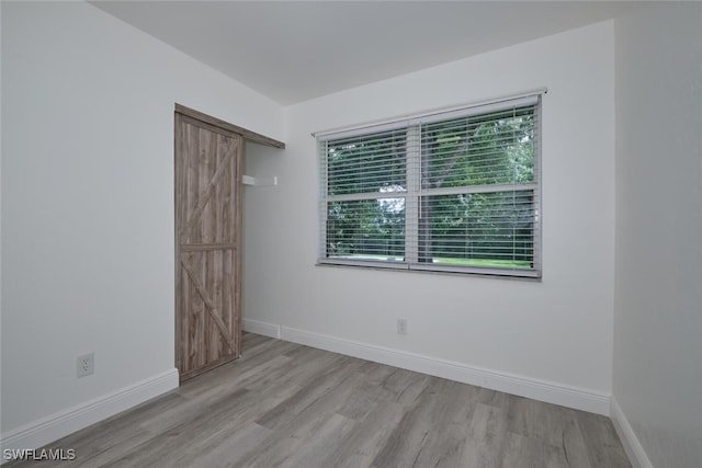 empty room with a wealth of natural light and light hardwood / wood-style floors