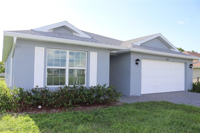 single story home featuring a garage and a front lawn