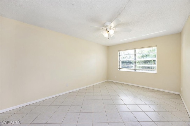 spare room with ceiling fan, light tile patterned floors, and a textured ceiling