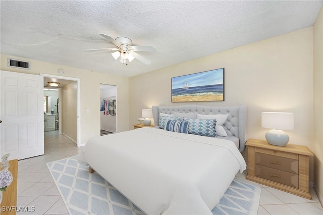 bedroom with light tile patterned floors, a closet, a spacious closet, and ceiling fan