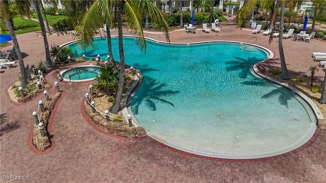 view of pool with a hot tub and a patio area