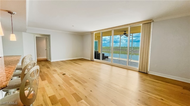 unfurnished living room featuring ornamental molding, hardwood / wood-style floors, and ceiling fan