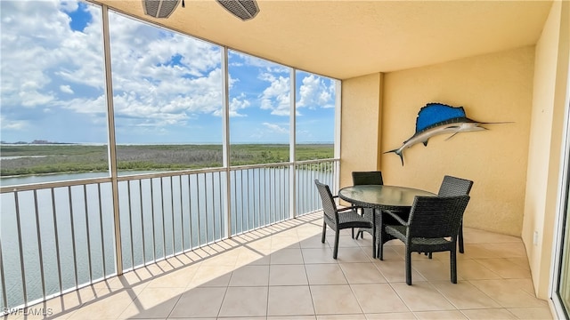 sunroom featuring a water view