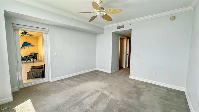 carpeted empty room with ceiling fan and crown molding