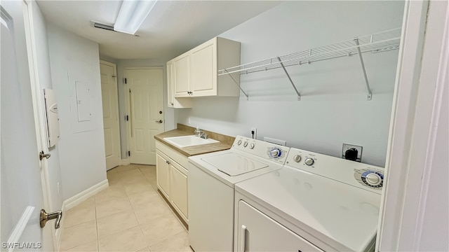 laundry area with light tile patterned floors, cabinets, sink, and washer and dryer