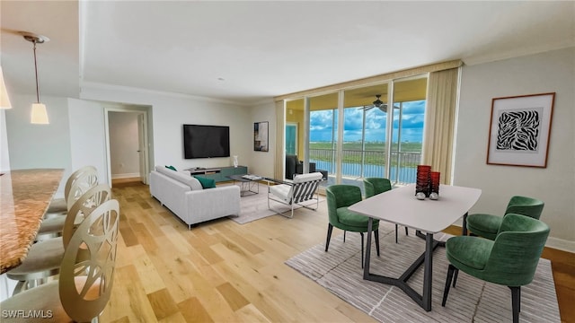 dining space featuring expansive windows, ceiling fan, crown molding, and light hardwood / wood-style flooring