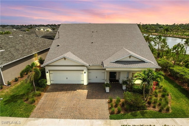 view of front of house featuring a garage and a water view