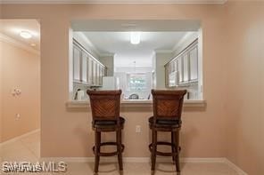 interior space with crown molding and a breakfast bar