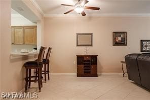 dining room featuring ceiling fan, ornamental molding, and light tile patterned flooring