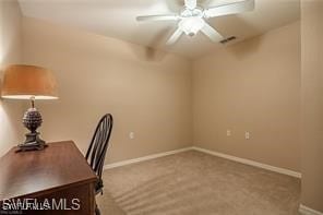 unfurnished office featuring ceiling fan and carpet