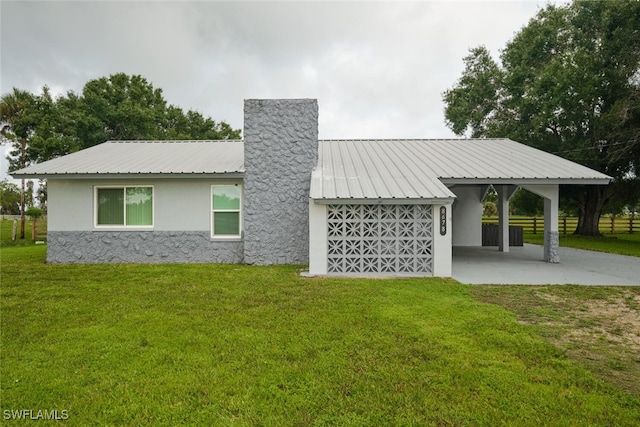 rear view of house featuring a lawn and a carport